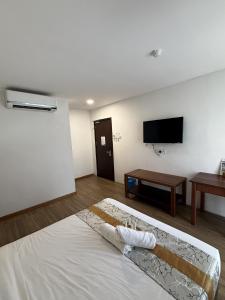 a bedroom with a bed and a flat screen tv at Palette - Bukit Mata Boutique Hotel in Kuching