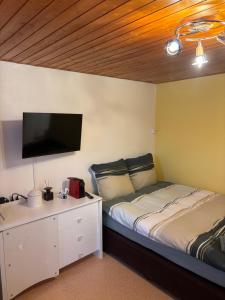 a bedroom with a bed and a flat screen tv at Ferienzimmer Appenzell in Appenzell