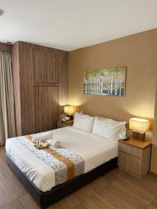 a bedroom with a large white bed with two lamps at Palette - Bukit Mata Boutique Hotel in Kuching +55 photos
