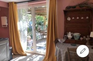 a kitchen with a table and a sliding glass door at La rosée in Montanay