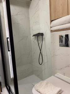 a shower with a hose in a bathroom at Natalia 2 in Mrągowo +4 photos