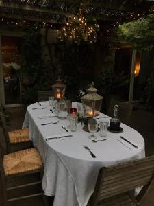a table with a white table cloth and candles on it at La rosée in Montanay
