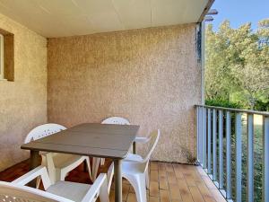 a table and white chairs on a balcony at Residence Thalassa in Calvi