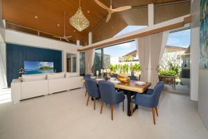 a dining room with a table and chairs and a couch at Wila villas Phuket Free Airoport Pick up from 7 days in Phuket