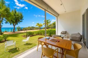 a dining room with a table and chairs and a view of the ocean at Beachfront Apartment with Garden & Direct Beach Access in Grande Gaube