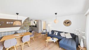 a living room with a blue couch and a table at Casa Terza - CharmingStay in Flumserberg