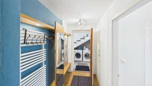a laundry room with a blue wall and a washer and dryer at Casa Terza - CharmingStay in Flumserberg