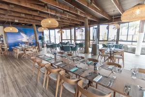 a dining room with tables and chairs and windows at Beach View Apartment 205 in Swakopmund