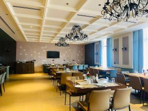 a restaurant with tables and chairs and a flat screen tv at Royal palm hotel and resort in Niāl
