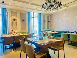 a restaurant with tables and chairs and a chandelier at Royal palm hotel and resort in Niāl