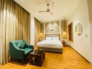 a hotel room with a bed and a chair at Royal palm hotel and resort in Niāl +44 photos