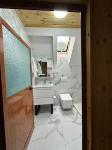 a white bathroom with a sink and a toilet at Bujtina Turkaj in Nikshi +19 photos