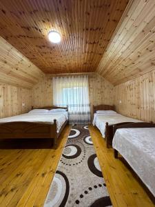 a large room with two beds and a rug at Bujtina Turkaj in Nikshi