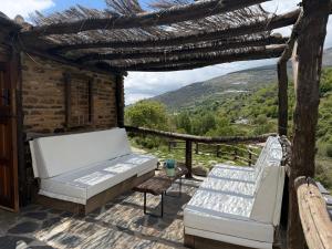 a patio with a couch and chairs and a view at CASA RURAL CORTIJO MOLINO ALTERO in Trevélez