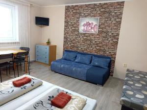 a living room with a blue couch and a brick wall at Abturist penzion in Štúrovo