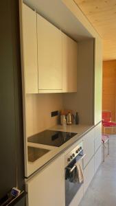 a kitchen with white cabinets and a stove top oven at Refugium in Schwaigen