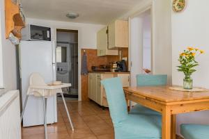 a kitchen and dining room with a wooden table and chairs at Hetedhét Vendégház in Mórahalom