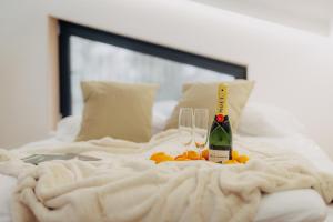 a bed with two glasses and a bottle of champagne at Monside Resort - EARTH CABIN in Borzont +8 photos