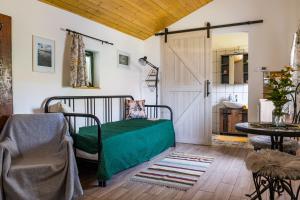 a bedroom with a bed and a door and a table at Hetedhét Vendégház in Mórahalom