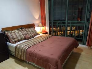 a bedroom with a bed and a large window at ORTIGAS 2 Br Corner Unit With 2 Queen Across Shangrila in Manila +17 photos