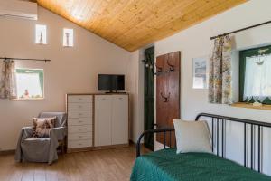 a bedroom with a bed and a tv and a chair at Hetedhét Vendégház in Mórahalom