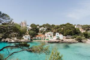 a group of houses on the shore of a river at Hostal Palmaria in Cala Santanyi
