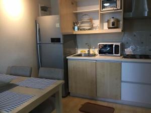 a small kitchen with a sink and a refrigerator at ORTIGAS 2 Br Corner Unit With 2 Queen Across Shangrila in Manila