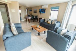 a living room with blue couches and a coffee table at Beach View Apartment 205 in Swakopmund