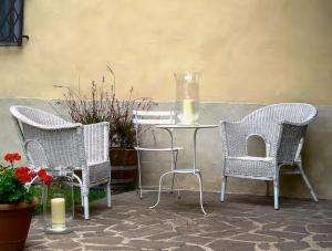 a table with three chairs and a table with a candle at Castello Sonnino in Montespertoli