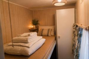 Ein Zimmer mit einem Bett und Handtüchern auf einem Regal. in der Unterkunft Spa-Francorchamps Forest Lodge in Amel