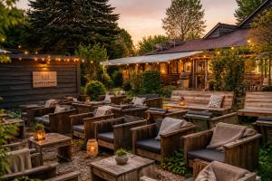 ein Restaurant mit Holzstühlen und -tischen und Lichtern in der Unterkunft Spa-Francorchamps Forest Lodge in Amel