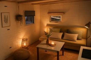 ein Wohnzimmer mit Sofa und Tisch in der Unterkunft Spa-Francorchamps Forest Lodge in Amel