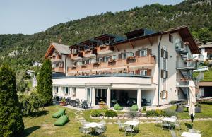 a hotel in the mountains with tables and chairs at Hotel Ludwigshof & Luvina in Trodena
