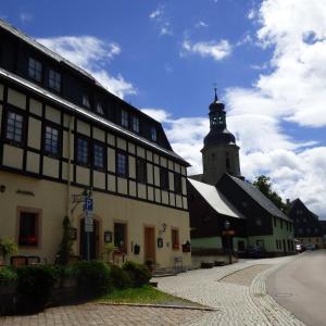 a building with a clock tower in a town at Ratskeller Geising in Geising