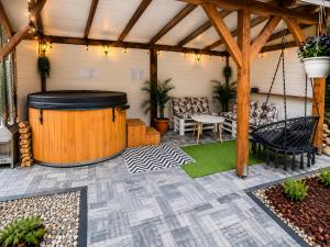a patio with a gazebo and a table and chairs at Biały Domek Świerczek - Jacuzzi, Balia Ruska SPA, Rowery, Altana i Grill w Słopnice in Słopnice