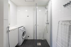 a bathroom with a shower and a washing machine at Hiisi Homes Vantaa Kulomäki in Jokivarsi +39 photos