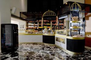 a restaurant with a counter with aasteryasteryasteryasteryasteryasteryasteryasteryastery at Airotel Stratos Vassilikos Hotel in Athens