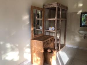 a wooden cabinet in a room with a sink at Nataliya Homestay in Ubud