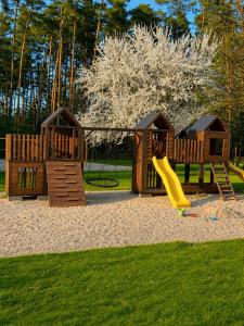 a playground with a slide and two play structures at Leśny Azyl in Zwierzyniec