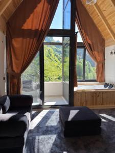 a living room with a couch and a large window at Ponte Butik Otel in Çamlıhemşin