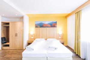 a room with two beds and a painting on the wall at Hotel Ludwigshof & Luvina in Trodena
