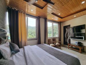 a bedroom with a bed and a large window at Hotel Rajinder Prasth in Dalhousie