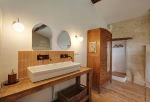 a bathroom with a white sink and a mirror at Small country house with authentic charm in Baurech +40 photos