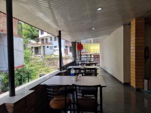 a restaurant with tables and chairs and a large window at Hotel Rajinder Prasth in Dalhousie