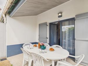 a white dining room with a white table and chairs at La Tranche-sur-Mer, maison pour 3 adultes-2 enfants in La Tranche-sur-Mer