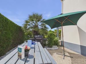 a green umbrella sitting on top of a wooden bench at La Tranche-sur-Mer, maison pour 3 adultes-2 enfants in La Tranche-sur-Mer +13 photos