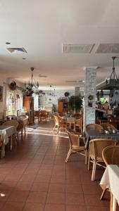 a restaurant with tables and chairs in a room at Hotel Auberge Restaurant in Schorfheide