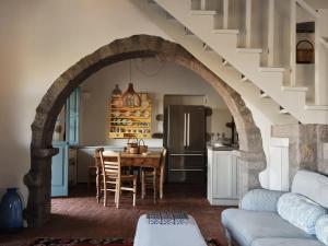 an archway in a living room with a table and a kitchen at Patmos Eye Boutique Hotel & Villas in Skala