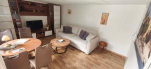 a living room with a white couch and a table at Ferienhaus Jurdzinski in Lengefeld