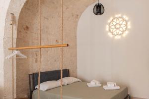 a swinging bed in a room with a wall at Aqua Suite - Stone Spa - A Few Minutes from Polignano, Monopoli & Alberobello in Castellana Grotte